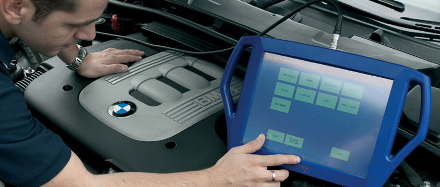 Technician running an Autologic diagnostic scan tool on a BMW engine